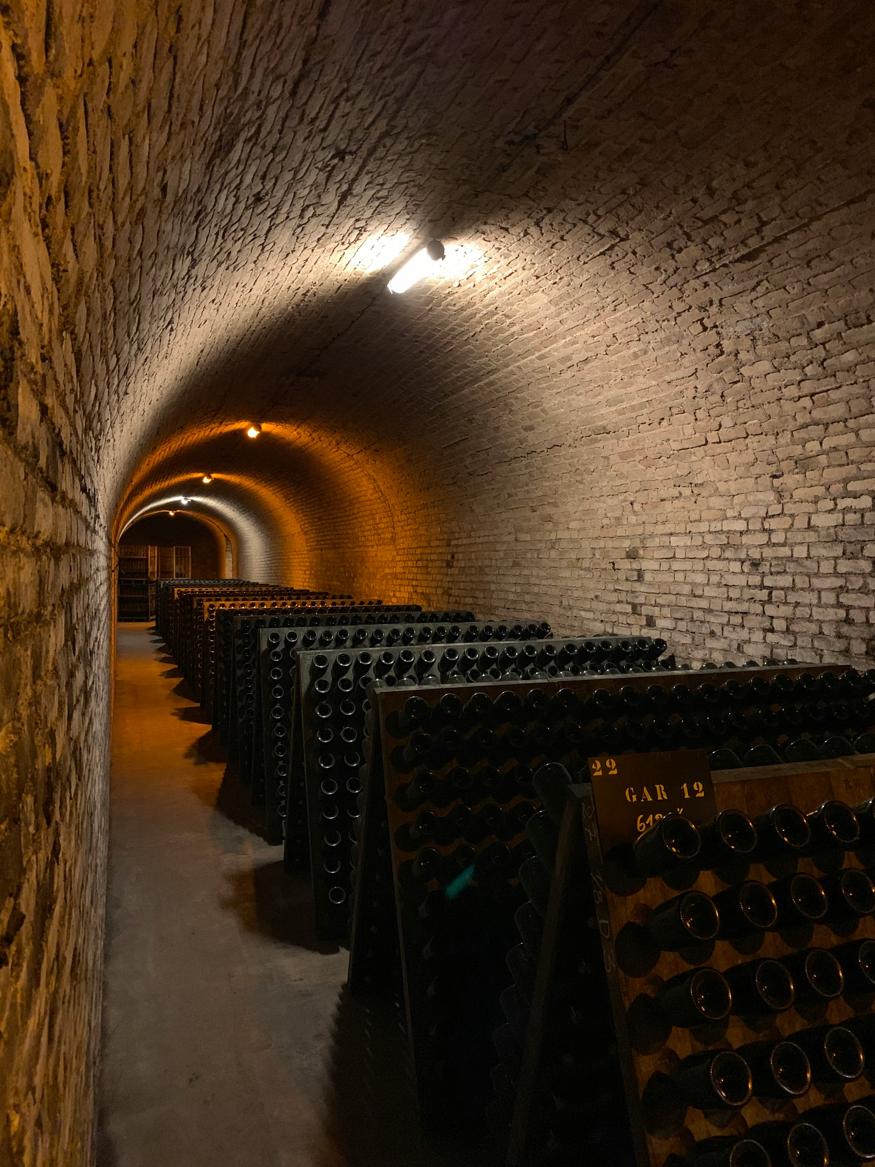 Entrée de cave voûtée avec bouteilles entreposées